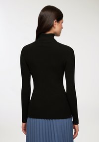 Czarny sweter z golfem, wykonany z ribbowanego materiału, z długimi rękawami i dopasowaną sylwetką, z lekko wydłużonym tyłem i miękką teksturą.