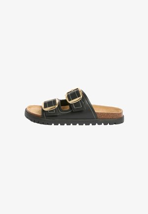 Sort slip-on sandal med to justerbare remme med store gyldne spænder og en brun polstret korkfodplade.