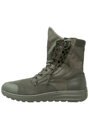 Wysokie militarne buty w oliwkowej zieleni z bocznym zamkiem błyskawicznym, sznurowaniem z przodu, wyściełanym kołnierzem przy kostce i teksturowaną gumową podeszwą.