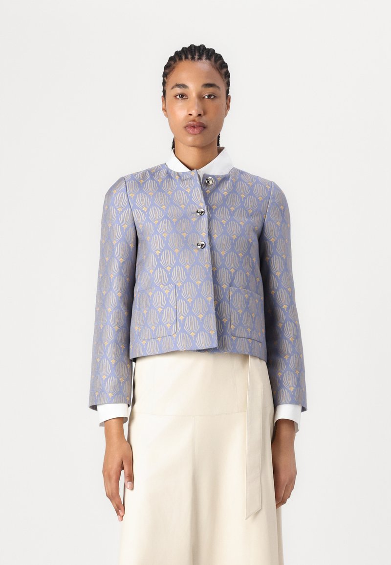 Blå cropped jakke med gullskallmønster, sølvknapper og hvit krage. Glatt tekstur, skreddersydd design og lange ermer.