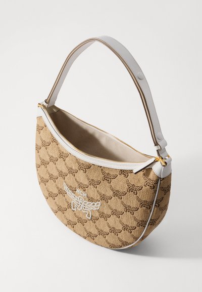 Beige félhold alakú kézitáska barna monogramos mintával, fehér bőrszíjjal és díszítéssel, arany cipzárral és hímzett MCM logóval az elején.