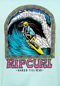 Ανοιχτό μπλε πουκάμισο με πολύχρωμη εικόνα ενός σκελετού που κάνει σερφ σε κύμα, με έντονες γραμμές και γεωμετρικό περίγραμμα. Το κείμενο γράφει "RIPCURL -SHRED TILL DEAD-".