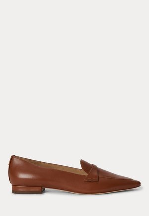 Zapato plano de cuero marrón con punta puntiaguda, tacón bajo y una correa sobre la parte superior, mostrado sobre un fondo claro y liso.
