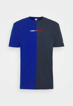 Koszulka z krótkim rękawem i zaokrąglonym dekoltem, w połowie królewsko niebieska, w połowie ciemnoszara, z logo "TOMMY JEANS" wyśrodkowanym, wykonanym białym, czerwonym i niebieskim ściegiem.
