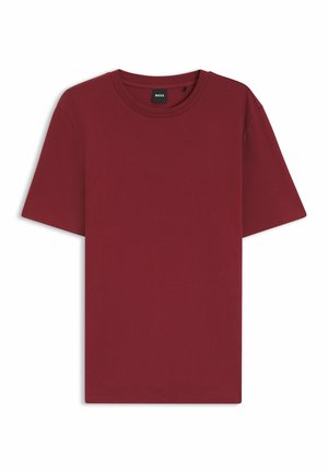 T-shirt uni bordeaux à manches courtes et col rond avec un tissu subtilement texturé et une petite étiquette noire à l'intérieur du col.