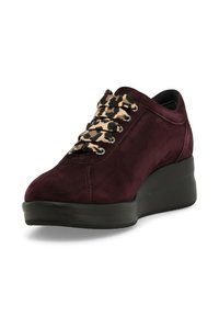Sneaker in suede bordeaux con suola in gomma nera. Presenta lacci con stampa leopardata e un design elegante con punta arrotondata e altezza imbottita.