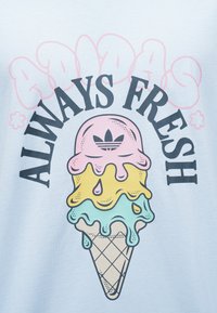 Cornet de glace à trois boules roses, jaunes et bleues dégoulinantes, logo Adidas en haut et texte « ALWAYS FRESH » en arc au-dessus.