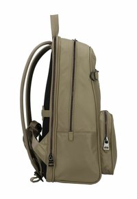 Mochila de tela beige con múltiples compartimentos con cremallera, correas acolchadas y un pequeño bolsillo frontal. Textura suave con costuras reforzadas.