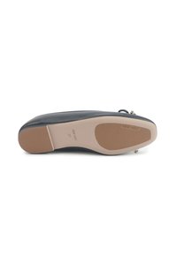 Chaussure plate noire avec semelle beige, coussinets en caoutchouc, et nom de la marque "Nine West" sur la semelle, taille 37, vue par le dessous.