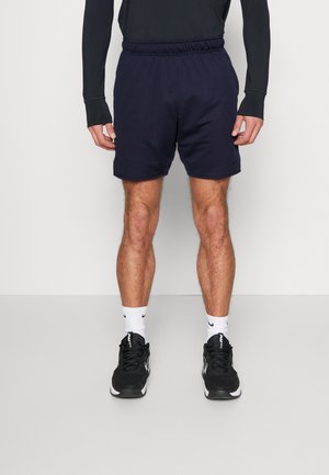 Navy athletic shorts with elastic waistband, paired with black sneakers and white socks. Features a clean, simple design without patterns.