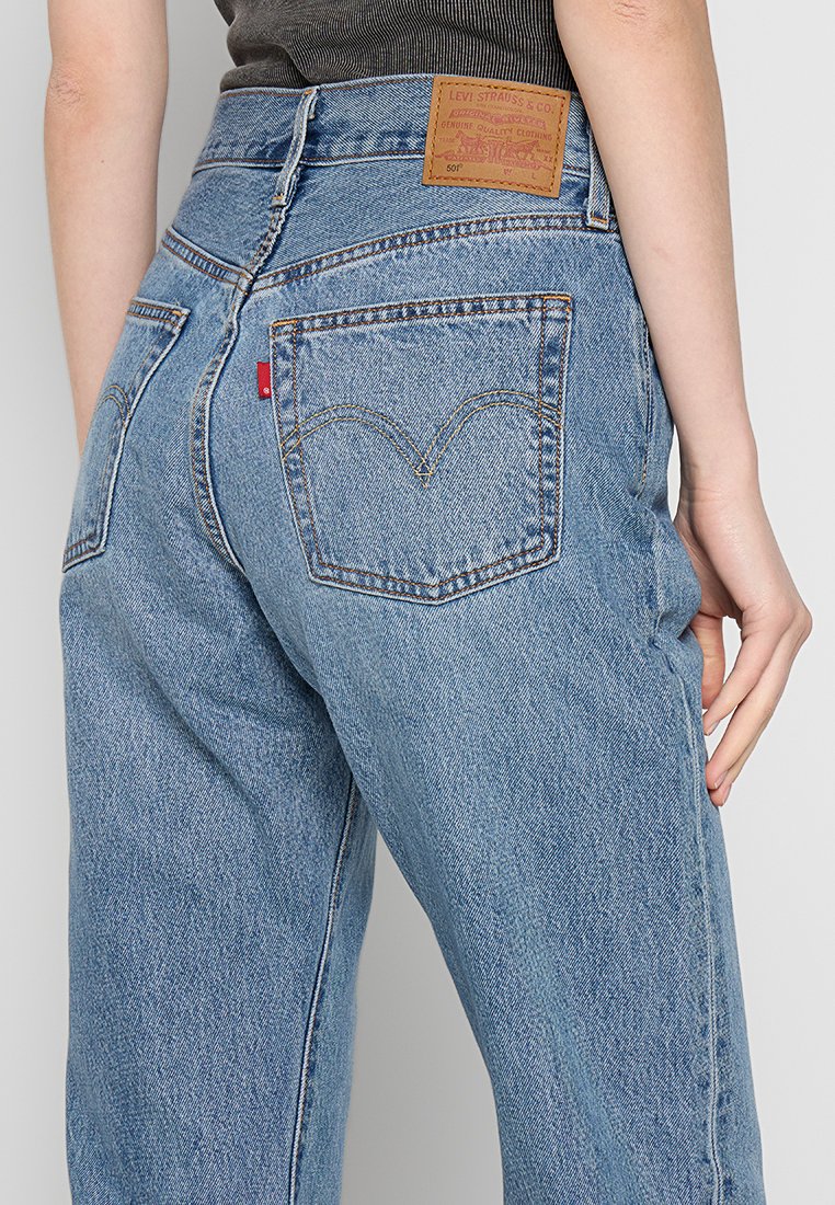 I jeans in denim azzurro chiaro presentano una vita alta, un design a gamba dritta, cuciture a contrasto e un'etichetta in pelle sulla cintura posteriore.