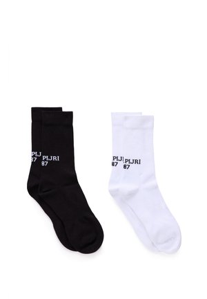 Pair of black socks and pair of white socks, each with ribbed cuffs and "PLJRI 87" text near the top.