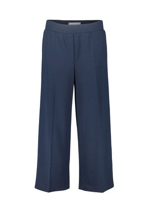 Pantalons larges bleu marine en tissu doux, avec une taille élastique et un design épuré et minimal sans poches visibles.