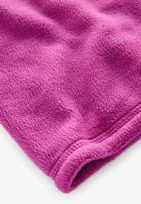Fleecefilt i stark rosa, texturerad yta med en mjuk, fluffig finish. Kanterna har en välgjord, sydd fåll för hållbarhet.