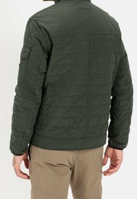 Mørkegrøn quiltet jakke med høj krave, der har diamantmønstre, elastiske manchetter og en lynlåslomme på venstre arm.