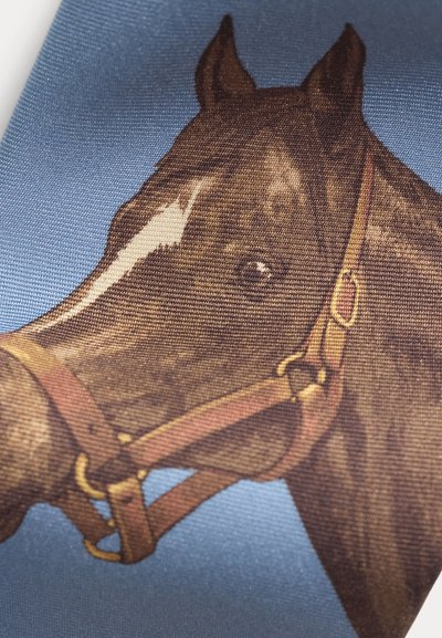 Κοντινή λήψη του κεφαλιού ενός καφέ αλόγου με δερμάτινο χαλινάρι σε φόντο μπλε υφασμάτινης υφής.