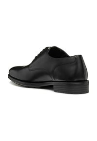 Scarpa in pelle nera con una finitura liscia, sistema di allacciatura chiuso e suola in gomma resistente con scanalature orizzontali per una migliore aderenza.