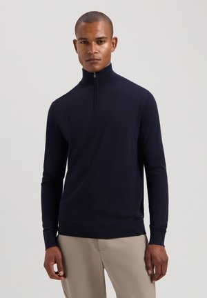 Marinefarbener Pullover mit Reißverschluss und langen Ärmeln, mit gerippten Bündchen und Saum, aus weichem Material gefertigt, taillierte Passform, glatte Textur, minimalistische Details.