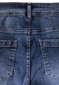 Mörkblå denimjeans med en slät textur, utrustade med en standard midjeresår, två bakfickor och kontrasterande guldiga sömmar.