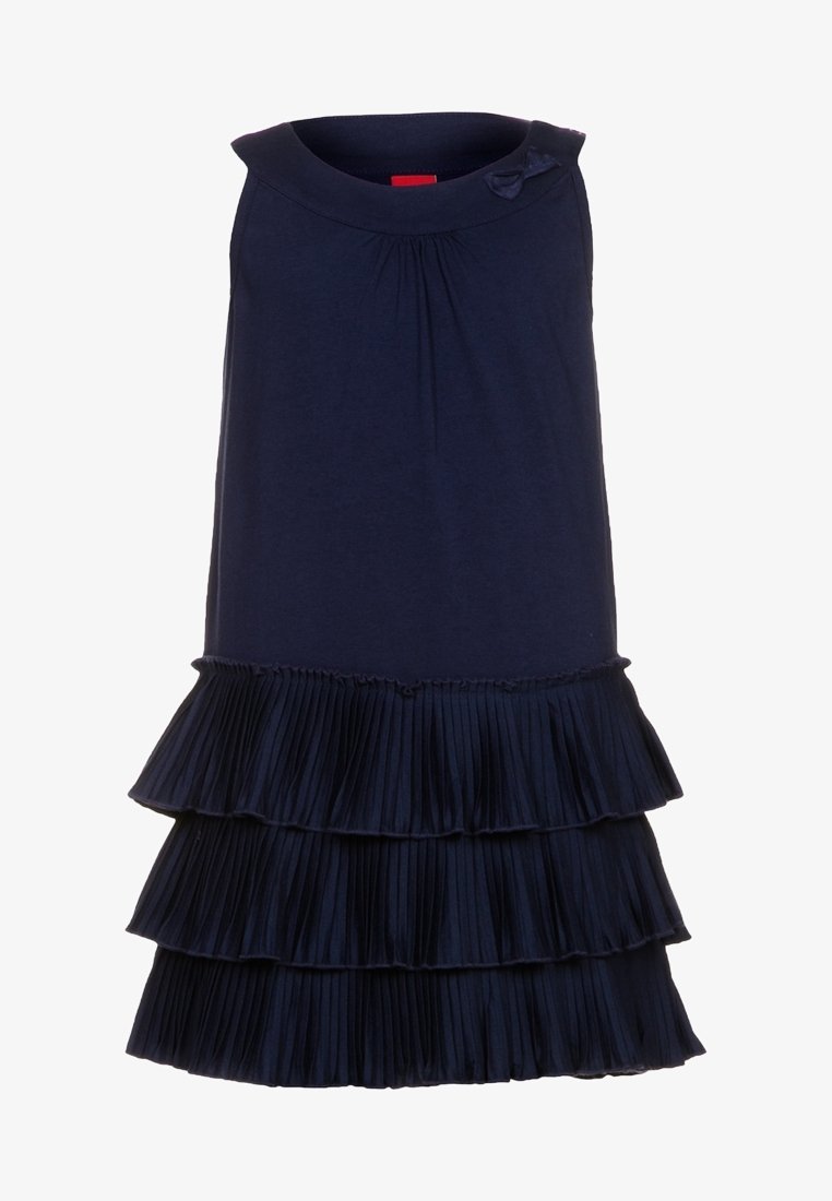 Granatowa sukienka bez rękawów z okrągłym dekoltem, wyposażona w plisowany falbaniasty dół oraz mały akcent w postaci kokardy blisko ramienia. Miękka tekstura materiału.