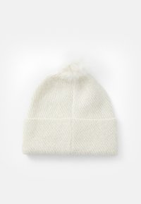 Valge kootud beanie, millel on tekstuuriga muster, karvane pom-pom peal ja allapoole volditud äär.