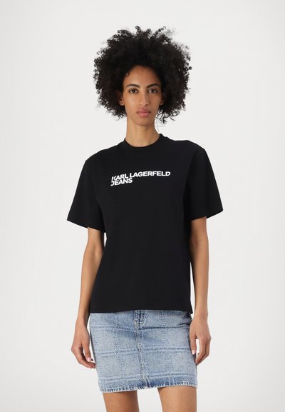 Черна памучна тениска с бяло лого "KARL LAGERFELD JEANS" на предната част, съчетана с светлосиня дънкова пола. Ежедневен кройка.