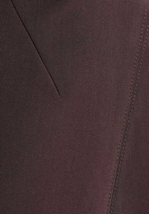 Donkerbruin stof met een gladde textuur, voorzien van een diagonale naaddetail. Het oppervlak lijkt lichtmatig met subtiele stikselaccenten.