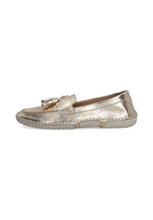 Flat slip-on shoe made of shiny gold leather, features a decorative strap with a buckle, rounded toe, and a textured rubber sole.