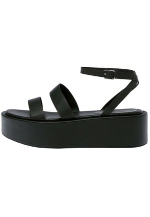 Sandale noire à plateforme avec deux larges brides et une sangle de cheville réglable avec une boucle en métal.