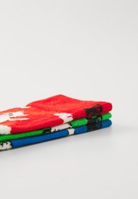 Trois paires de chaussettes en rouge, vert et bleu. Chaque chaussette présente des motifs d'animaux : un chien sur la chaussette rouge, et un chat sur les chaussettes verte et bleue, respectivement.