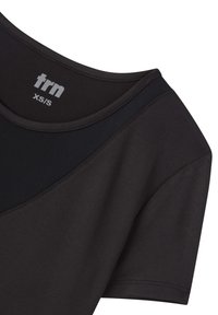 T-shirt sportivo nero con colletto rotondo, caratterizzato da un pannello testurizzato a contrasto e un'etichetta del marchio stampata "trn XS/S" sul colletto.