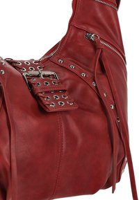 Borsa in pelle rossa con borchie metalliche, cerniere e dettagli con fibbie. Il design è morbido con una silhouette scivolata e cuciture dettagliate.