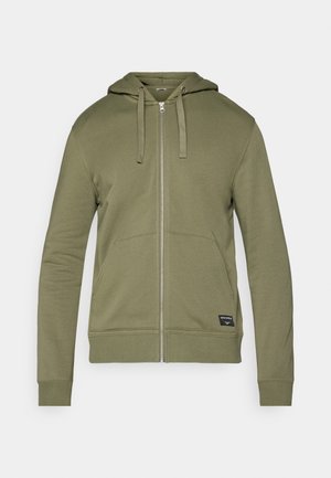 Olive green zip-up hoodie with a hood, two front pockets, ribbed cuffs, and a label on the bottom right. Soft cotton blend fabric.