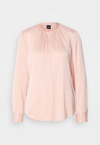 Blouse rose pâle à manches longues, encolure ronde, plis subtils au col et boutons avant dissimulés.