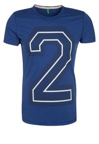 Blå bomullströja med en stor vit kontur av siffran "2" på framsidan. Kortärmad och med rundad halsringning. Slät textur.