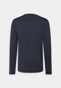 Camisa de manga larga de color azul marino hecha de una tela suave; escote redondeado, textura lisa, sin patrones ni acentos visibles. Diseño de corte estándar.