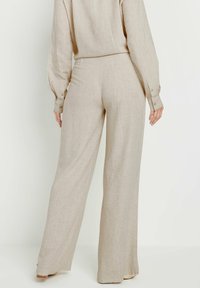 Beige linnen wijde broek met een textuurfinish, met een hoge taille en knopen op de manchetten. Eenvoudig en neutraal ontwerp.