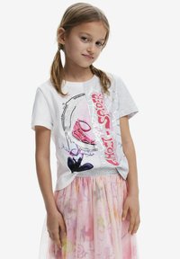 Vit och grå stickad t-shirt med en Spider-Man grafisk print i rosa och svart, korta ärmar, rund halsringning och en avslappnad passform.