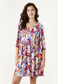 Korte mouwen jurk met een V-hals, featuring een kleurrijk bloemenpatroon in roze, rood, blauw en beige. Uitlopende rok, lichtgewicht stof.