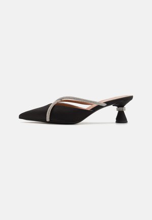 Musthave mustrekiga musta satiinist, terava varbaga slingback kingad, millel on hõbedane sädelev rihm ja ainulaadne skulpturaalne konts. Ühtlane tekstuur kogu kinga ulatuses.