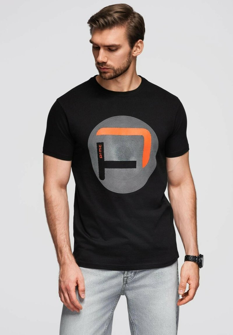 Černé bavlněné tričko s kulatým grafickým potiskem na šedém pozadí a oranžovým obdélníkovým akcentem. Krátké rukávy, normální střih.