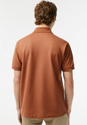 Braunes Polohemd aus glattem Stoff, mit kurzen Ärmeln und klassischem Kragen. Die Rückseite zeigt ein einfaches Design mit geradem Saum.