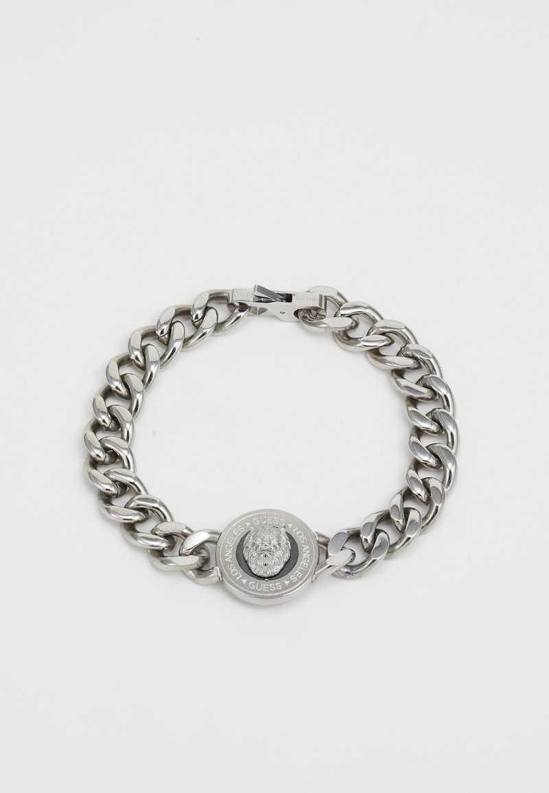 Bracelet en argent avec des maillons épais et un fermoir rond arborant un emblème de lion. Texture lisse avec une finition poli.