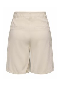 Shorts beige taille haute sur mesure avec passants de ceinture, deux poches passepoilées au dos et un tissu légèrement texturé.