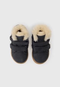 Čierne kožené topánky s béžovou kožušinou, s dvoma čiernymi suchými zipsami a gumovou podrážkou. Nízky dizajn s zaoblenými prstami.