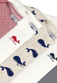 Τέσσερα μπλουζάκια: λευκό με κόκκινο λογότυπο φάλαινας, μπεζ με σχέδια φάλαινας σε ναυτικό μπλε, και κόκκινο/λευκό ριγέ. Απαλό βαμβακερό υλικό, σχέδιο με στρογγυλή λαιμός.