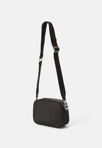 Borsa a tracolla nera realizzata in tessuto liscio, con forma rettangolare, chiusura con zip e tracolla regolabile con marchio.