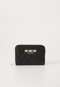 Portefeuille zippé noir en matériau texturé, présentant un motif matelassé et une fermeture en métal doré avec le logo "GUESS".