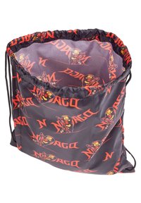 Sac en tissu noir avec cordon de serrage, orné d'un imprimé sur le thème de Ninjago en rouge et orange, présentant des illustrations de ninjas et des motifs de logo.