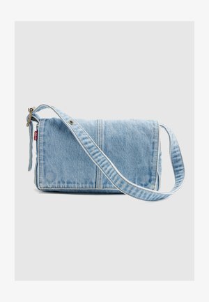 Lyseblå denim skulderveske med justerbar stropp og Levi's røde merke på venstre side, satt mot en ensfarget lys grå bakgrunn.